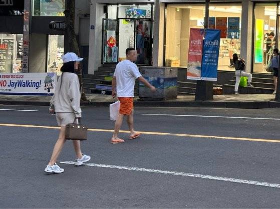 지난 25일 오후 7시 35분께 제주시 연동의 한 차로를 무단횡단하는 20대 중국인 커플. 이들은 정복 경찰이 앞에 있는데도 무심히 무단횡단을 했다. 최충일 기자