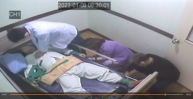 12일 이상 격리·강박돼 있던 김형진(가명·45살)씨가 사망 상태로 발견되자 당직의사 안 아무개씨가 심폐소생술을 시도하고 있다. 그 와중에 보호사와 간호사가 손과 발을 묶은 끈을 풀어내고 있다.