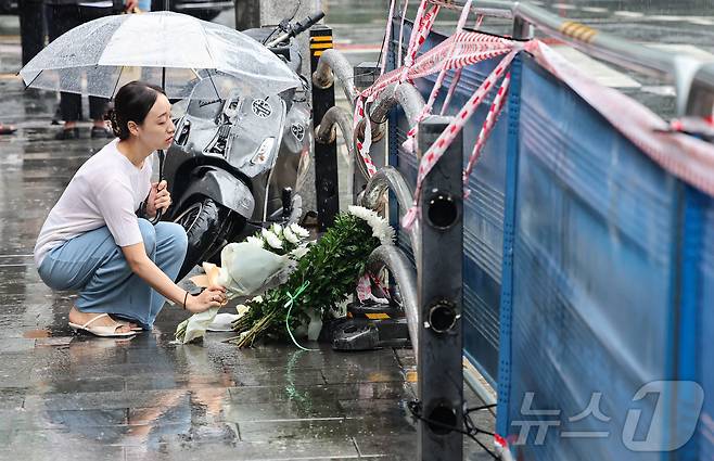 지난밤 승용차가 인도로 돌진해 9명이 사망하는 사고가 발생한 2일 오전 서울 중구 서울시청 인근 교차로 사고현장에서 한 시민이 희생자를 추모하며 헌화를 하고 있다. 이번 사고로 9명이 사망하고 4명(중상 1명·경상 3명)이 다쳤다. 사망자 9명 중 6명은 현장에서 사망했으며, 3명은 병원 이송 도중 숨졌다. 2024.7.2/뉴스1 ⓒ News1 김도우 기자