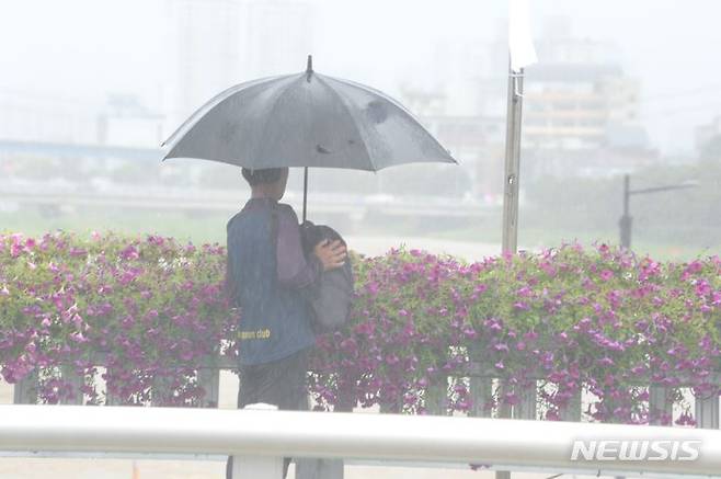 [청주=뉴시스] 조성현 기자 = 호우특보가 발효된 2일 오전 충북 청주시 흥덕구 서문동 청주대교 위에서 한 시민이 무심천을 바라보고 있다. 2023.07.02. jsh0128@newsis.com