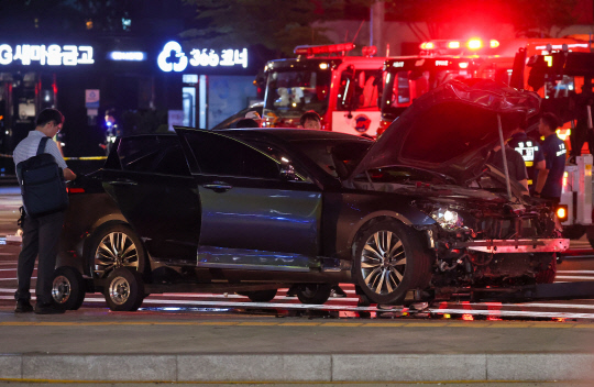 2일 오전 전날 대형 교통사고가 발생한 서울 시청역 인근 교차로에서 경찰이 완전히 파괴된 차량 한 대 주변을 통제하고 있다.연합뉴스