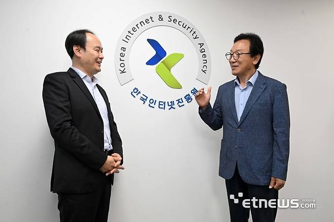 이상중 한국인터넷진흥원(KISA) 원장(오른쪽)과 안호천 AI데이터부 부장이 KISA 로고 옆에서 KISA 미래 비전에 대해 이야기를 나누고 있다. 김민수기자 mskim@etnews.com
