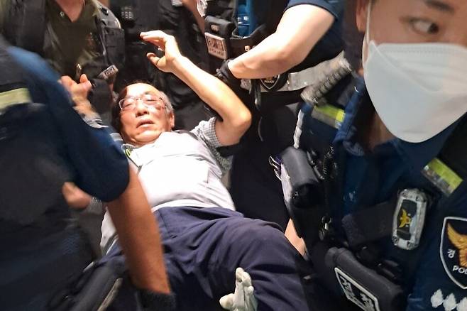 3일 12시40분경 서울 중구 퇴계로 남산스퀘어빌딩 6층 진실·화해를위한과거사정리위원회(진실화해위) 사무실에서 농성하던 김명운 한국전쟁전후민간인피학살자전국유족회(피학살자유족회) 자문위원장이 경찰관들에 의해 들려 나가고 있다. 고경태 기자