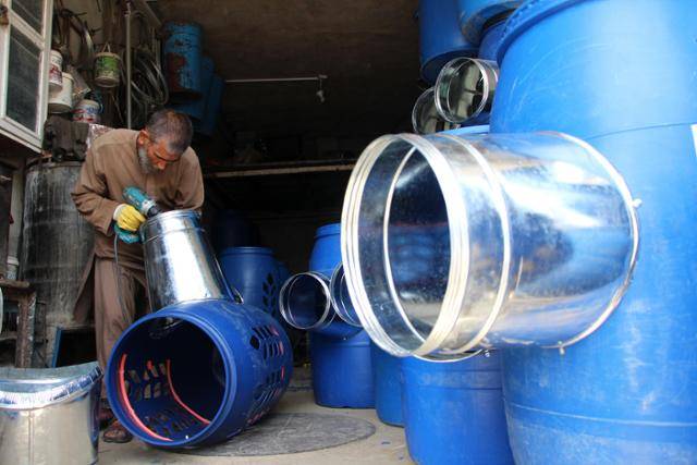 3일 아프가니스탄 칸다하르에서 한 노동자가 태양광으로 작동되는 냉각장치를 만들고 있다. 지난주부터 기온이 오르기 시작한 칸다하르는 이번 주 평균 기온이 섭씨 46도로 높고 더 오를 것으로 예상되고 있다. 칸다하르=EPA 연합뉴스