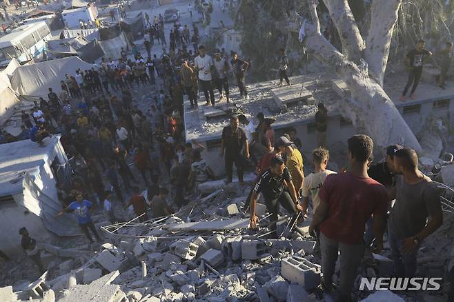 [칸유니스=AP/뉴시스]  7월3일 가자지구 칸유니스에서 팔레스타인 주민들이 이스라엘의 공습으로 파괴된 주거용 건물 잔해 속에서 희생자 시신과 생존자를 찾고 있다. 2024.07.04.