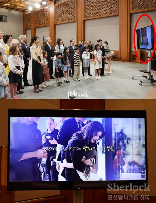 ▲ 김건희 여사가 5월 21일 전시장을 방문했을 당시, 아이들과 함께 '젤렌스카 여사의 영상메세지'를 보는 모습.(위) 하지만 일반 관람객들에겐 김건희 여사의 노고(?)를 전달하는 영상을 상영하고 있었다.(아래) ⓒ셜록