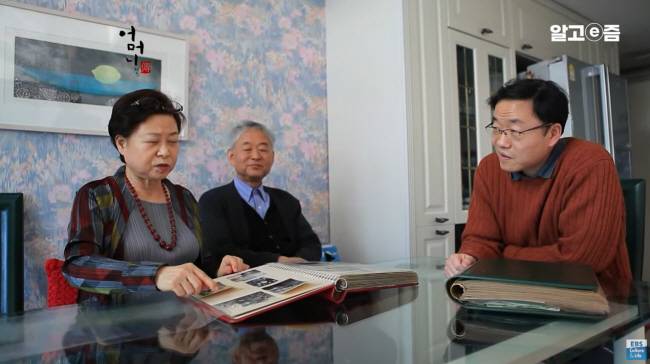 지난 2012년 방송된 EBS ‘어머니 전(傳)’의 한 장면. 한말숙(왼쪽)·황병기(가운데) 부부가 큰아들 황준묵 당시 고등과학원 교수와 함께 황 교수의 어린 시절 앨범을 들여다보고 있다.  EBS 캡처