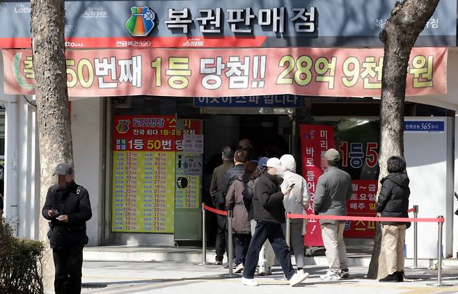 [서울=뉴시스] 최진석 기자 = 8일 서울 한 복권판매점에서 고객들이 줄지어 복권 구입을 기다리고 있다. 기획재정부 복권위원회에 따르면 지난해 복권 발행액은 7조330억원으로 전년(6조8898억원)보다 2%가량 늘었다. 판매액(6조7507억원)도 전년(6조4292억원)보다 5% 증가했다. 복권 종류별로는 로또 판매액(5조6526억원)이 가장 많았고 스피또 등 인쇄복권(6580억원), 전자복권(1251억원) 등이 뒤를 이었다. 2024.03.08.