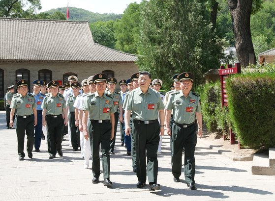 지난 6월 17일 시진핑 중국 국가주석(앞줄 가운데)이 옌안에서 소집한 중앙군사위 정치공작회의 중 마오쩌둥의 거주지를 군 수뇌부와 시찰하고 있다. 시 주석은 옌안회의에서 “현재 당과 군내 분위기에 심각한 변화가 발생했다”며 “총자루는 충성하고 믿을 수 있는 자가 장악해야 한다”며 향후 추가 숙청을 예고했다. 신화=연합뉴스