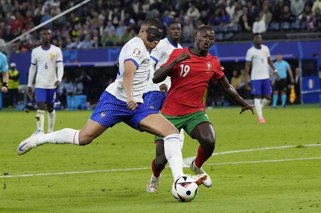 Kylian Mbappe of France, left, and Portugal's Nuno Mendes vie for the ball during a quarter final match at the Euro 2024 soccer tournament in Hamburg, Germany, Friday, July 5, 2024. (AP Photo/Hassan Ammar)<저작권자(c) 연합뉴스, 무단 전재-재배포, AI 학습 및 활용 금지>