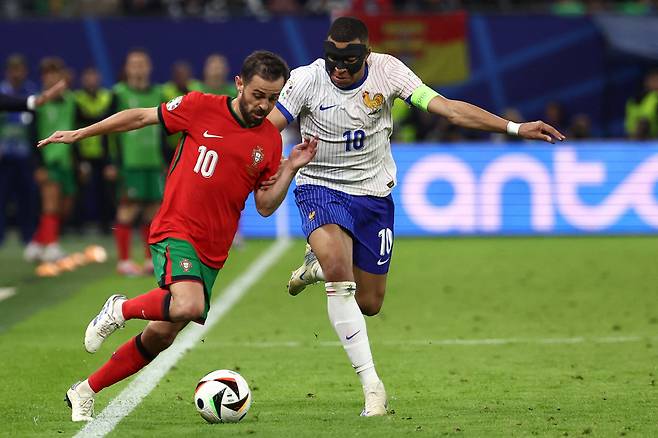TOPSHOT - France's forward #10 Kylian Mbappe (R) fights for the ball with Portugal's midfielder #10 Bernardo Silva during the UEFA Euro 2024 quarter-final football match between Portugal and France at the Volksparkstadion in Hamburg on July 5, 2024. (Photo by FRANCK FIFE / AFP)<저작권자(c) 연합뉴스, 무단 전재-재배포, AI 학습 및 활용 금지>