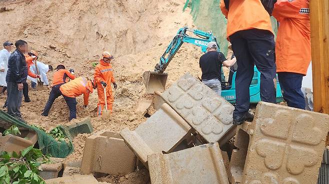 8일 오전 산 비탈면 붕괴로 토사가 흘러내린 충북 옥천군 옥천읍 한 주택에서 50대 남성이 실종됐다는 신고가 접수돼 소방 당국이 수색작업을 하고 있다.