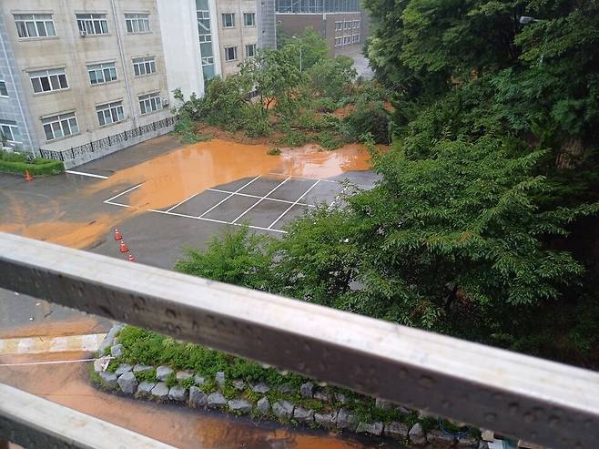 10일 오전 전북 군산의 한 중학교 뒷산에서 산사태가 발생해 토사가 도로에 흘러내리고 있다. 독자 제공