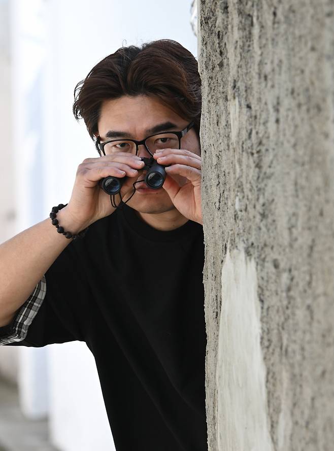 Cho Sung-min poses for a photograph in Huam-dong, Seoul. The binoculars are a prop. (Lim Se-jun/The Korea Herald)