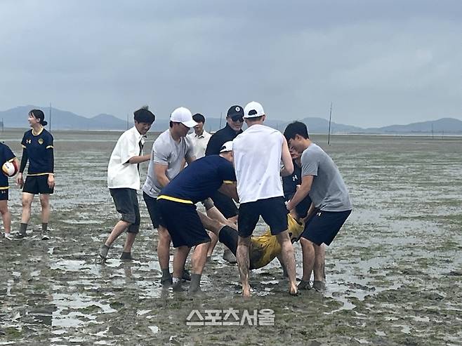 강제로 갯벌에 빠지게 하는 선수들과 스태프. 무안 | 강예진 기자