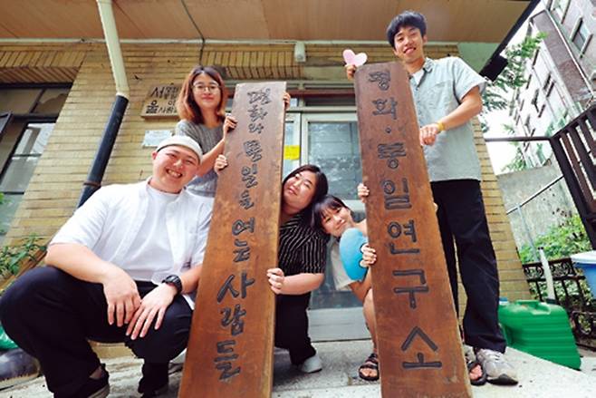 평통사 청년 활동가들이 평화와통일을여는사람들 입간판을 들고 서 있다.