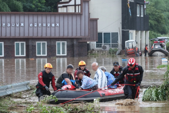 10일 새벽 내린 폭우로 침수된 대전 서구 용촌동의 한 마을에서 소방구조대원들이 주민을 구조하고 있다. 0시부터 오전 5시까지 평균 86.5㎜의 비가 내리며 이 마을 전체가 침수돼 27가구 주민 36명이 고립됐으나 인명 피해 없이 모두 구조됐다.  대전 뉴스1