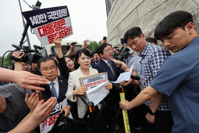 전현희(가운데) 더불어민주당 의원 등 국회 야당 법사위원들이 12일 윤석열 대통령 탄핵 국민청원 청문회 추진과 관련, 대통령실에 증인출석요구서 수령을 촉구하며 서울 용산 대통령실을 항의 방문하던 중 경찰에 가로막혀 항의하고 있다. 이한호 기자