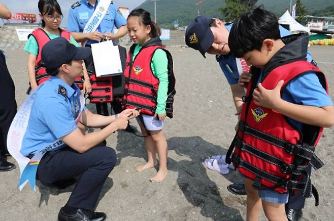 해경교육원 신임 학생이 어린이를 대상으로 구명조끼 착용법을 알려주고 있다. 해경교육원 제공