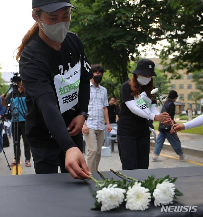 [청주=뉴시스] 서주영 기자 = 오송참사 유가족이 지난 11일 충북 도청 정문 앞에서 열린 참사 1주기 결의대회에서 희생자를 추모하는 헌화를 하고 있다. 2024.07.11. juyeong@newsis.com