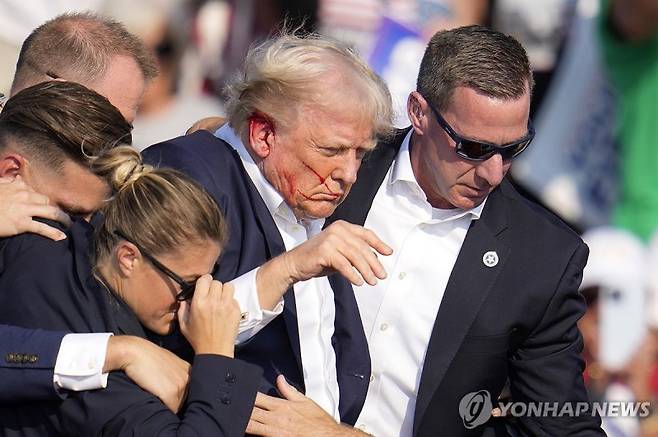 미국 공화당 대선후보 도널드 트럼프 전 대통령이 13일(현지시간) 펜실베이니아주 버틀러에서 열린 유세에서 총기 피습을 당한 후 경호를 받고 있다. AP연합뉴스