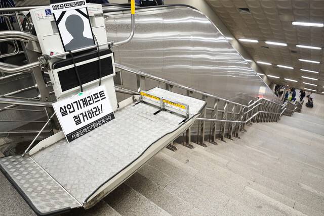 2018년 10월19일 서울 지하철 1·5호선 신길역 환승 통로에서 열린 ‘신길역 장애인 리프트 추락 사고 1주기 추모제’ 모습. 2017년 10월 신길역에서 장애인 휠체어 리프트 버튼을 누르려다 추락해 숨진 고 한경덕(69)씨를 기리는 추모제였다. 연합뉴스