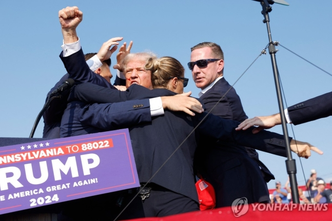 13일(현지시간) 미국 펜실베이니아 유세장서 총격 사건이 발생한 뒤 경호원들에 둘러 싸인 도널드 트럼프 전 대통령 [AFP = 연합뉴스]