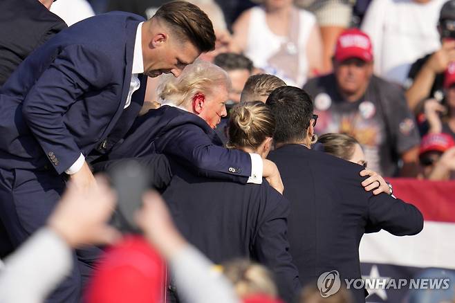 Election 2024 Trump Republican presidential candidate former President Donald Trump is helped off the stage at a campaign event in Butler, Pa., on Saturday, July 13, 2024. (AP Photo/Gene J. Puskar)