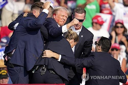 귀에 피묻은 상태로 급히 퇴장하는 트럼프  [AP=연합뉴스]