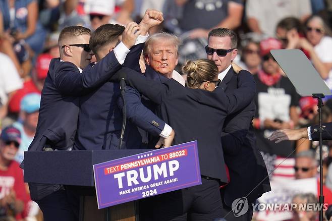 귀에 피묻은 상태로 급히 퇴장하는 트럼프  [AP=연합뉴스]