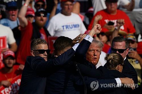 피흘리며 대피하는 트럼프 [버틀러 [미 펜실베이니아주] AFP=연합뉴스. 재판매 및 DB 금지]