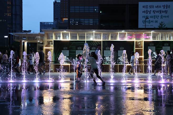 무더운 날씨가 이어진 14일 밤 서울 광화문광장 분수대에서 아이들이 물놀이하며 더위를 식히고 있다. 연합뉴스