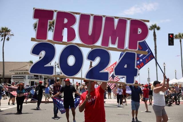 14일 미국 캘리포니아주 헌팅턴비치에서 열린 도널드 트럼프 공화당 대선후보 지지 집회에서 한 지지자가 '트럼프 2024'라고 적힌 팻말을 들어 보이고 있다. 헌팅턴비치=로이터 연합뉴스