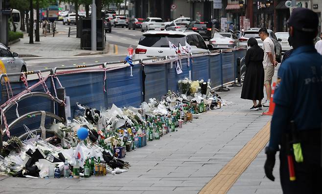 Bouquets of white chrysanthemums, drinks and commemorative messages are laid near Exit No. 7 of City Hall Station in Seoul on July 7, six days after a deadly car crash that resulted in nine deaths. (Yonhap)