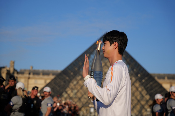 Jin carries the Olympic torch in Paris on July 14. [BIGHIT MUSIC]