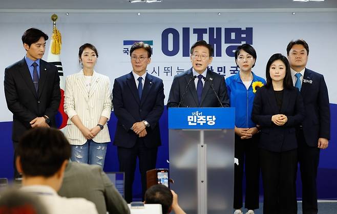 더불어민주당 이재명 전 대표가 7월 10일 서울 여의도 당사에서 8·18 전당대회 당 대표 출마를 선언한 뒤 취재진 질문에 답하고 있다. 이 대표 뒤로 왼쪽부터 한준호, 강선우, 김민석, 전현희, 김지호 최고위원 후보가 서 있다. 뉴스1