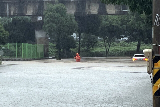 전남 동부권에 호우경보가 내려진 16일 오후 전남 여수시 중흥동 중흥천 인근 도로가 침수돼 소방대원이 안전조치를 하고 있다. 여수소방서 제공. 연합뉴스