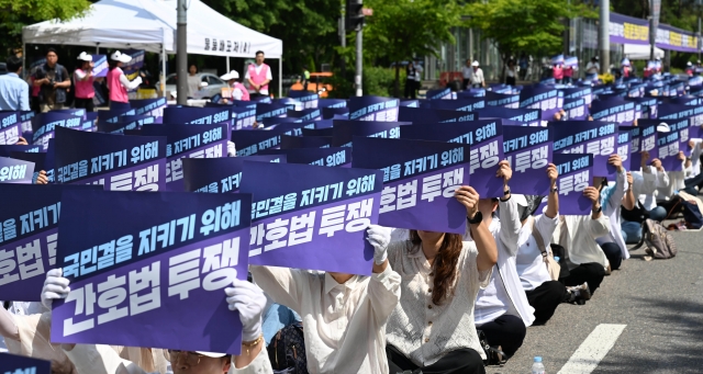 5월 23일 서울 여의도 국회의사당역 인근에서 열린 '전국 간호사 간호법안 제정 촉구 결의대회'에서 대한간호협회 회원들이 손 피켓을 들고 구호를 외치고 있다. 이한형기자