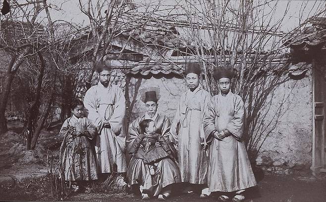 갑신정변의 주역 홍영식 일가. 우정국 책임자였던 홍영식(우측 두번째)와 그의 아버지 홍순목(중앙) 등 홍영식 가족. 홍순목은 강경 수구파의 우두머리로 영의정을 역임했다. 홍순목은 아들 홍영식이 갑신정변을 일으켜 3일 만에 실각하고 살해되자 며느리, 손자와 함께 자살했다. [미국 보스턴미술관(퍼시벌 로웰 촬영)]