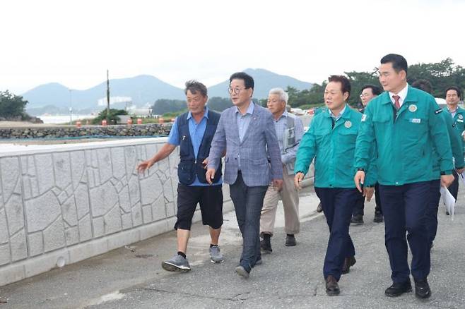 박완수 경남도지사(앞줄 왼쪽 세 번째)와 박종우 거제시장이 학산자연재해위험지구에 설치된 월파방지공을 살펴보고 있다. [사진제공=경남도청]