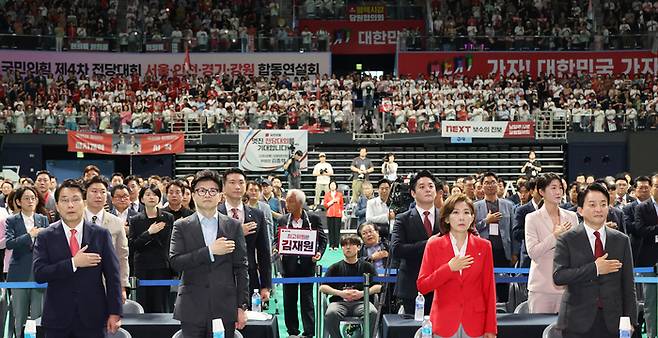 국민의힘 당 대표 후보들이 17일 오후 경기 고양시 고양 소노 아레나에서 열린 제4차 전당대회, 서울 인천 경기 강원 합동연설회에서 국기에 경례하고 있다. 앞쪽 왼쪽부터 윤상현, 한동훈, 나경원, 원희룡 당 대표 후보.