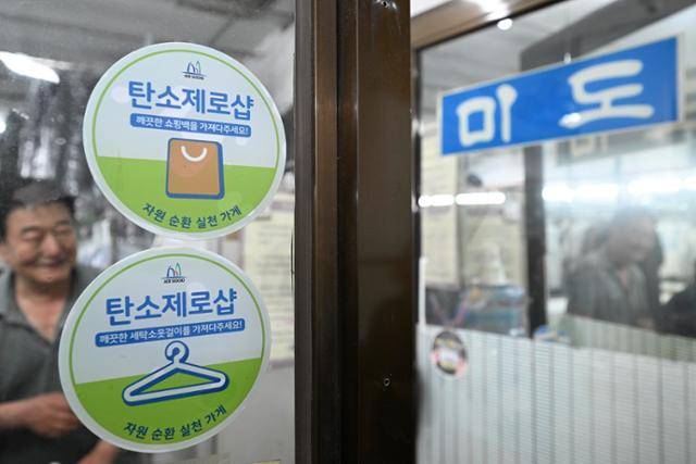 탄소제로샵에 참여 중인 미도세탁소 앞에 '깨끗한 세탁소 옷걸이를 가져다주세요' '깨끗한 쇼핑백을 가져다주세요'라고 적힌 스티커가 붙어 있습니다. 가게마다 재사용하는 품목이 다르지만 현재 카페 종이 트레이, 아이스팩, 비닐봉투, 호일 보냉팩, 쇼핑백, 세탁소 옷걸이, 종이 충전재, 뽁뽁이(에어캡) 등 8종을 받고 있다고 하네요. 정다빈 기자