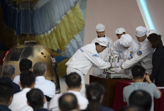 지난달 29일 중국 베이징에서 중국국가우주국(CNSA) 연구진들이 달 탐사선 ‘창어 6호’가 달에서 채취한 토양 샘플을 확인하고 있다. 신화통신=연합뉴스