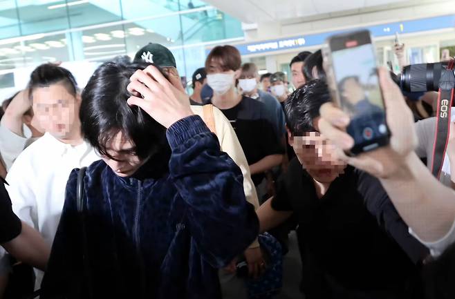 Wonbin of Riize arrives at the Incheon International Airport after the group's concert in Taiwan, while fans surround him to take his pictures, June 16. (Dispatch official Youtube)