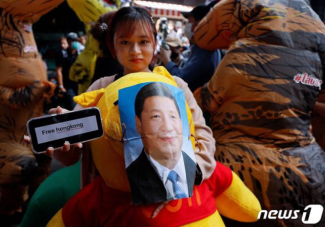 태국 방콕에서 열리는 아시아태평양경제협력체(APEC) 정상회의를 앞둔 17일(현지시간) 여성 시위자가 시진핑 중국 국가주석의 초상화를 '위니더푸' 곰돌이 인형에 붙이며 평화를 촉구하는 시위를 벌이고 있다. ⓒ 로이터=뉴스1 ⓒ News1 정윤영 기자