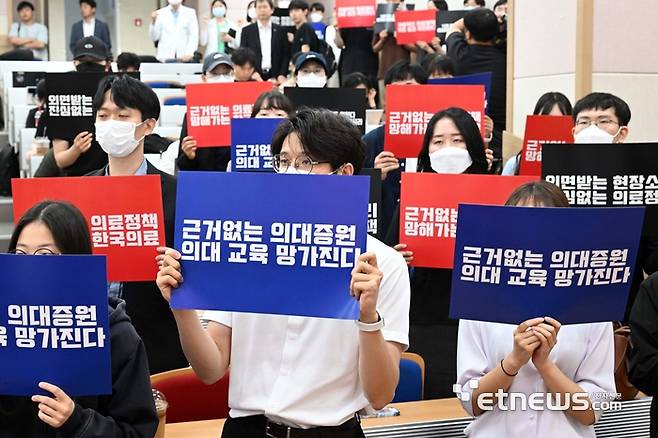 지난 달 17일 서울 종로구 서울대학교 의과대학에서 열린 '서울대학교병원 교수 휴진 선포 기자회견'에서 의료진이 피켓을 들고 구호를 외치고 있다. 김민수기자 mskim@etnews.com