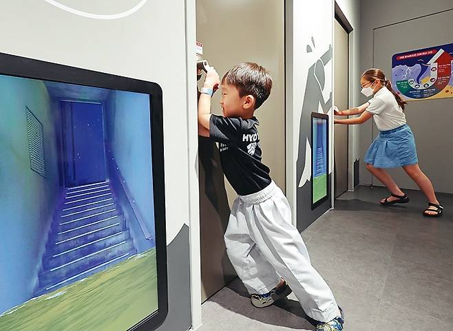 초등학생들이 집중호우로 침수된 지하실 문을 열고 나가는 체험을 하고 있다. 어른 무릎 정도만 물이 차도 문을 열기 어렵다.