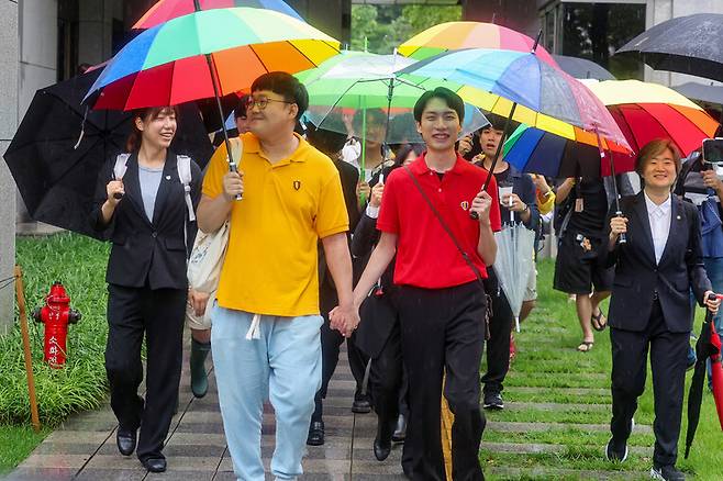 동성 연인 건강보험 피부양자 자격과 관련해 국민건강보험공단을 상대로 제기한 보험료 부과 처분 취소 소송에서 승소한 소성욱씨와 김용민씨(오른쪽)가 손을 잡고 밝은 표정으로 서울 서초구 대법원을 떠나고 있다. 연합뉴스