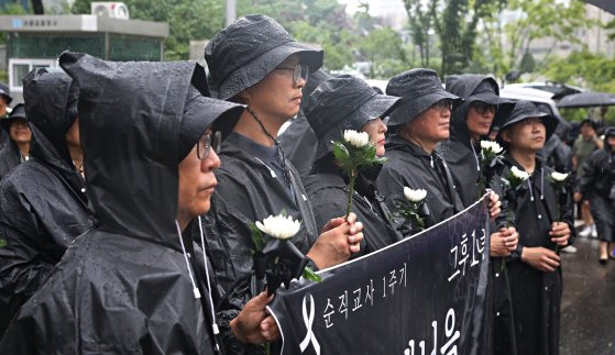 18일 오후 서울 서초구 서초경찰서 앞에서 교사유가족협의회 관계자와 전국교직원노동조합 조합원들이 추모의 의미로 국화를 들고 있다. 뉴스1