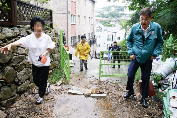 정문헌(오른쪽) 종로구청장이 지난 17일 계곡물 및 토사 유출이 발생한 곳을 찾아 피해 상황을 확인하고 있다.   종로구 제공